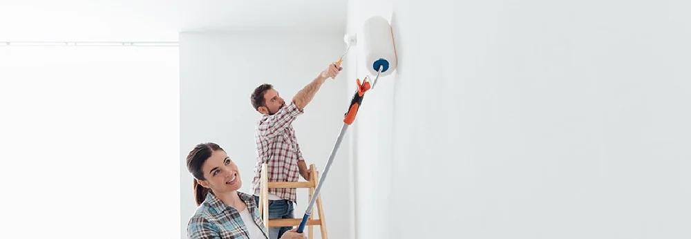 Personen streichen Wand weiß mit Farbroller